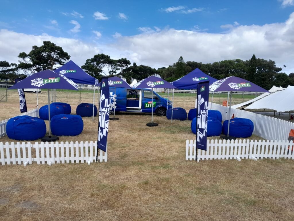 Isilumko-Activate A tent set up in a field with blue and white umbrellas, attracting the attention of street-level marketing teams.