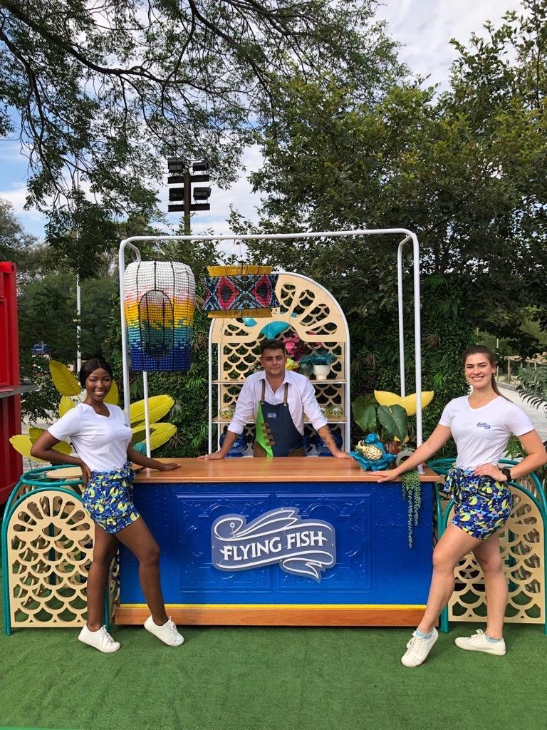 Isilumko-Activate Three women forming a street-level marketing team, posing for a photo in front of a booth.