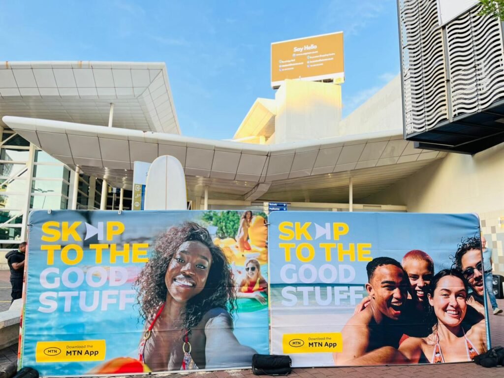 Isilumko-Activate A group of people marketing for a business with banners in front of a building.