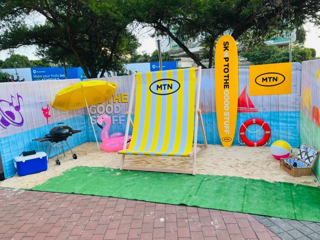 Isilumko-Activate A marketing campaign featuring a sandbox enhanced with chairs and a beach umbrella.