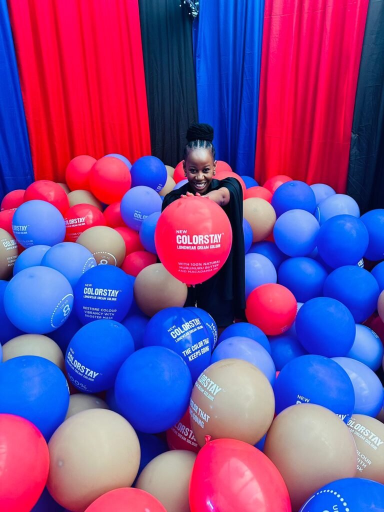 Isilumko-Activate A woman standing in a room filled with colorful balloons.