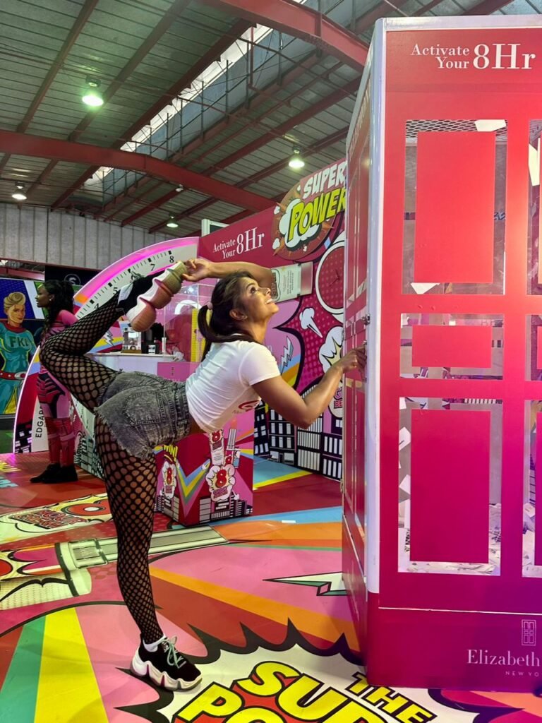Isilumko-Activate A woman is posing in front of a pink box.