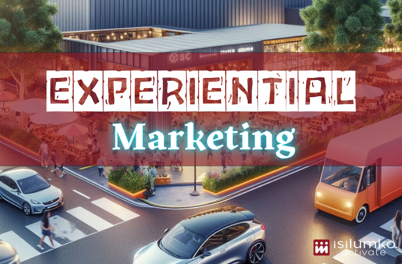 Isilumko-Activate Aerial view of a street with cars, a truck, and a building with outdoor seating. Text overlay reads "Experiential Marketing.